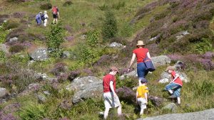 Family-Climbing-Over-Boulders-On-A-Hike